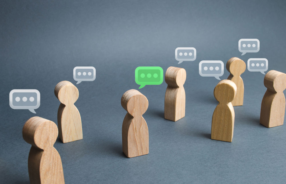 Wooden figures with speech bubbles.
