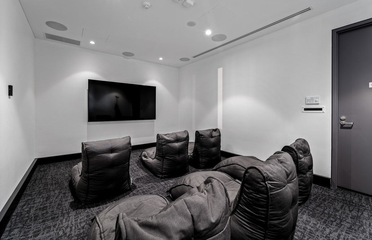Film screeing room with chairs pointed towards screen.